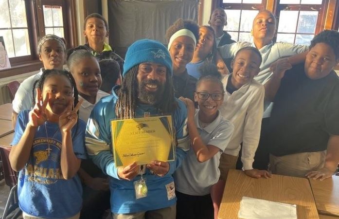  Teacher surrounded with students taking picture